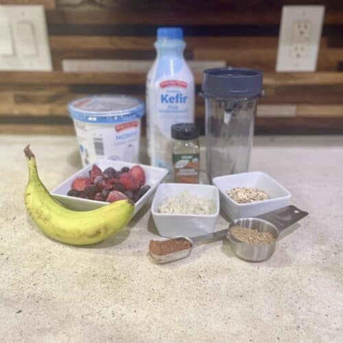 Mediterranean diet smoothie ingredients with berries, banana, Greek yogurt, kefir, oats, ground flaxseed, cocoa powder, cinnamon, and rice cauliflower