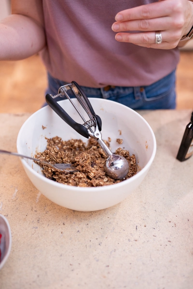 A cookie scoop portioning anti-inflammatory protein balls from a mixing bowl