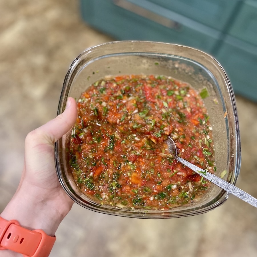 Fresh anti-inflammatory salsa with tomatoes, peppers and cilantro in a glass storage container.