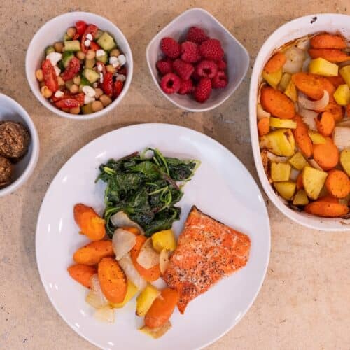 Anti-inflammatory meal with salmon, roasted vegetables, leafy greens, chickpeas, berries, and healthy snacks for hot flash support.