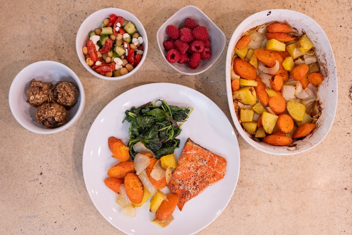 Anti-inflammatory meal with salmon, roasted vegetables, leafy greens, chickpeas, berries, and healthy snacks for hot flash support.