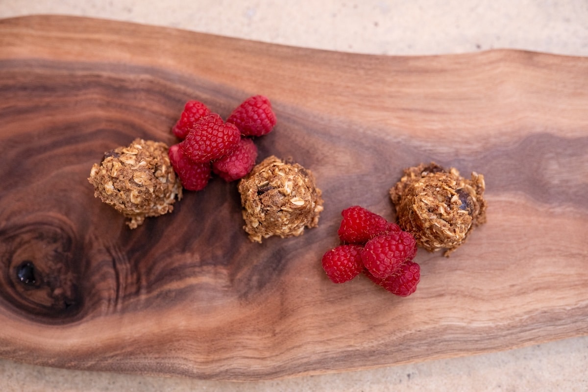 No-bake energy bites served with raspberries for an easy prep-ahead anti-inflammatory snack.