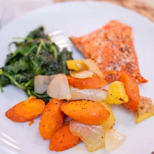 Salmon with roasted potatoes and sautéed greens, a Mediterranean-style dinner for a fatty liver diet
