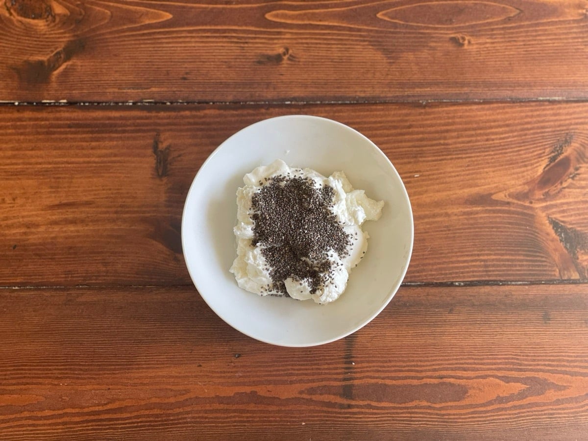 Bowl of plain Greek yogurt topped with chia seeds, viewed from above